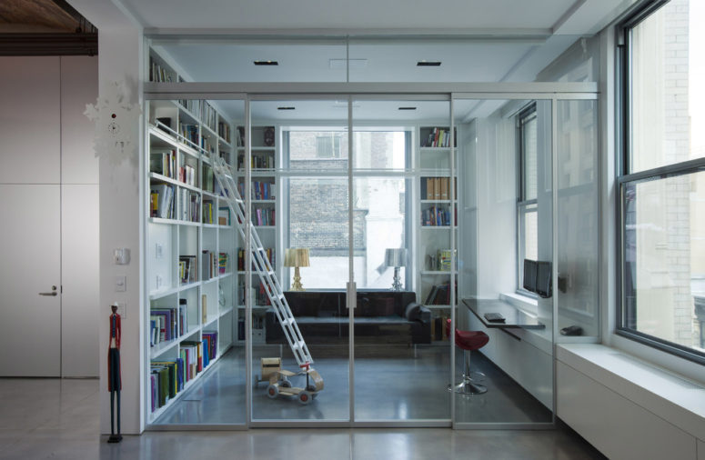 an enclosed home office/library behind a glass wall with sliding doors