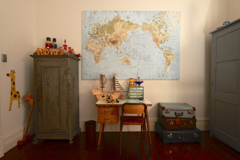 This is how you could rock both, a stack of vintage suitcases and a world map in a kids room (Jeni Lee).
