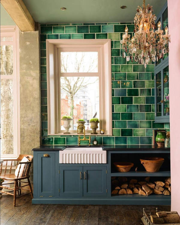 This English country kitchen features dark stained wood floors, handmade green tiles and gorgeous crystal chandelier for a glam feel