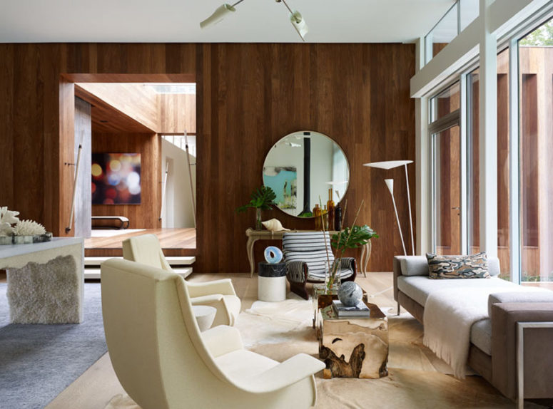 A warm-colored wood wall is a partition, and a glazed one connects the living room with outdoors