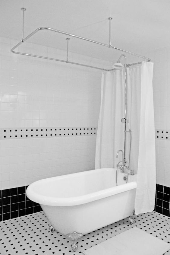 a classic clawfoot tub and shower in a timeless black and white bathroom
