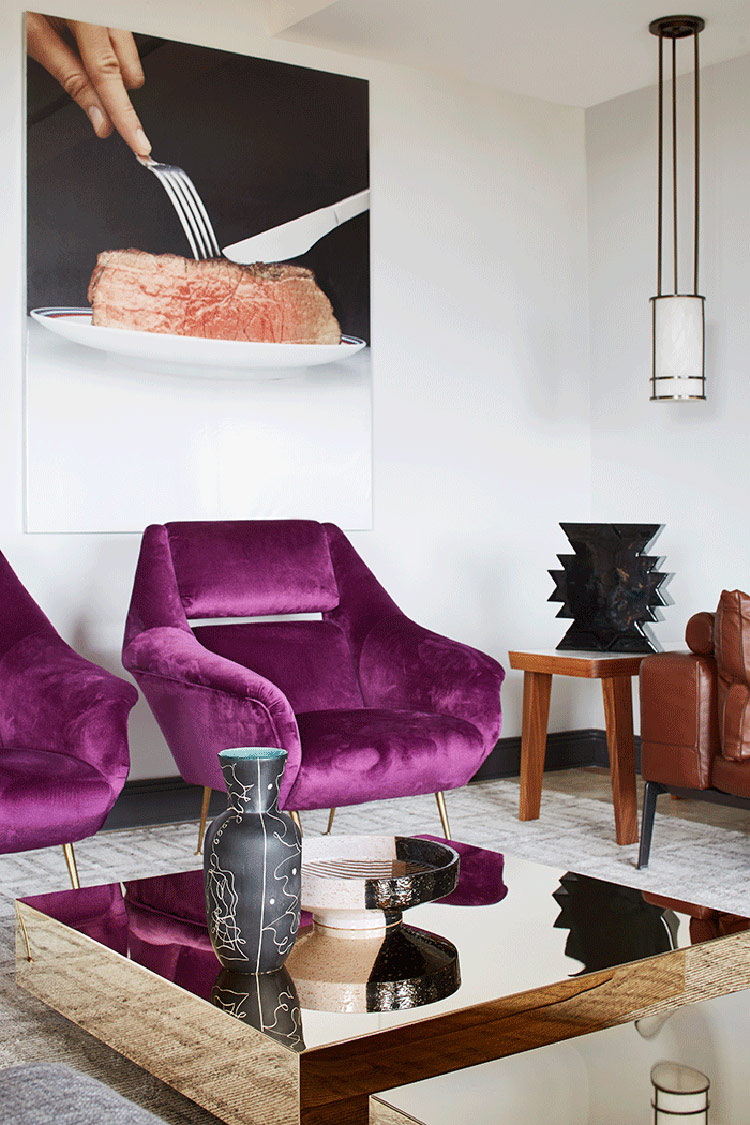 Purple upholstered chairs, gold mirror tables and creative oversized photos on the wall make the space unique