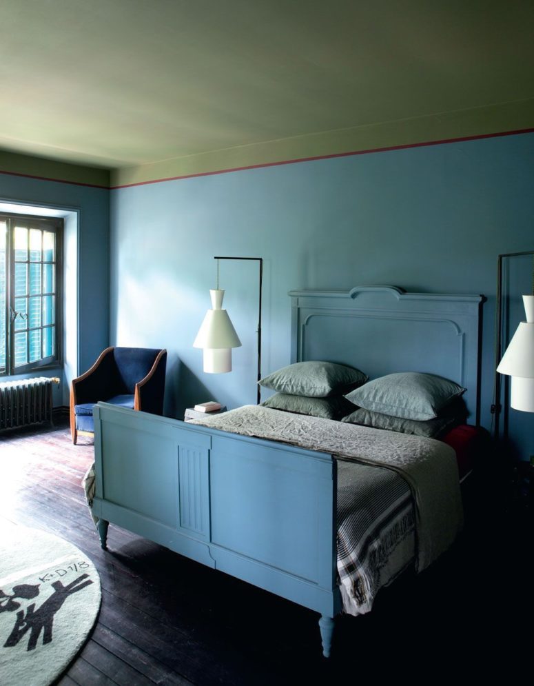 The master bedroom is done in blue shades, it features cool architectural lamps and a cobalt blue chair