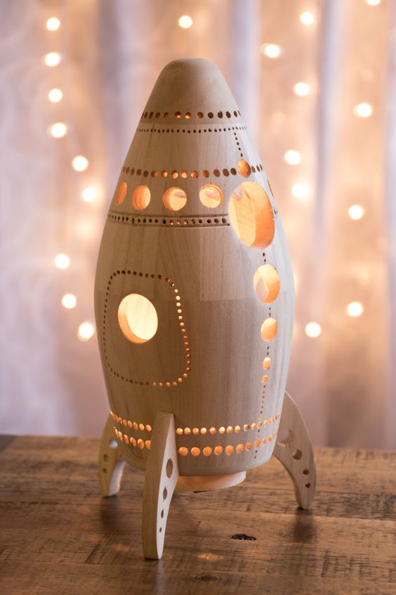 A carved wooden rocket lamp is ideal for a space themed boys' bedroom