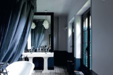 04 The master bathroom is refined, with teal, black and white and vintage sinks and a bathtub
