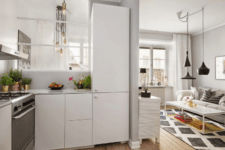 05 The kitchen is white with metallic accents and a false window going to the bedroom