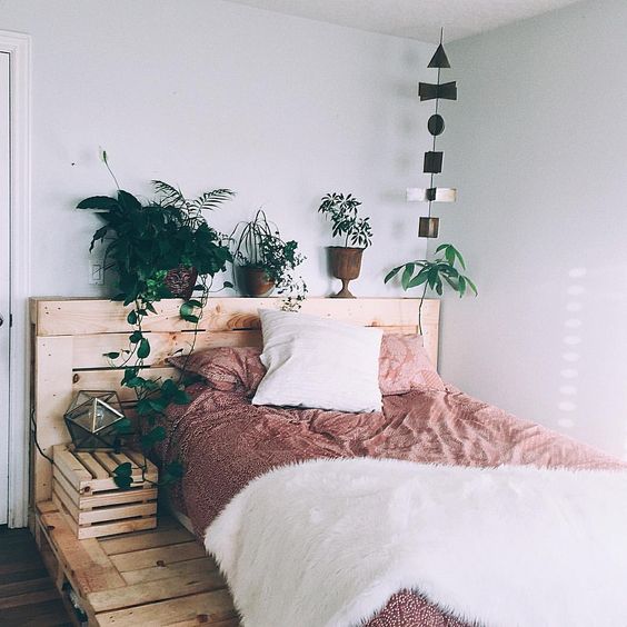a rustic bed made of pallets can be made more feminine with pink bedding and faux fur