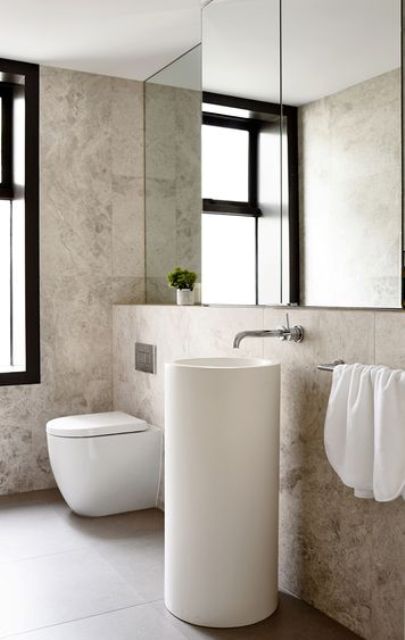 A small round free standing sink makes the bathroom modern