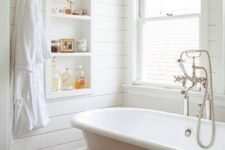 06 all-white bathroom with wooden floors for a rustic feel, a white tub with white legs