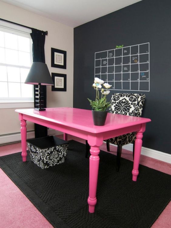 bold pink desk in a black home office makes a statement