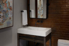 07 The powder room is decorated with graffiti, there’s a dark tile wall and a stained wood sink stand