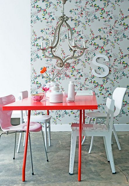 a cute red dining table and a blush chair make the space girlish
