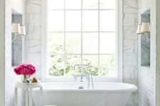 07 a glam bathtub niche with marble tiles, a flower stand and a large window for a cool view