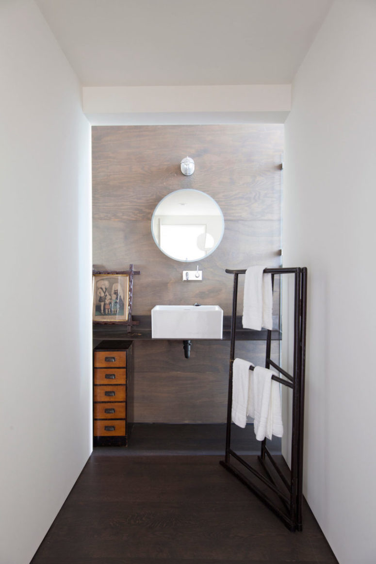 The bathroom is decorated with wooden panels, modern furniture and retro towel holders