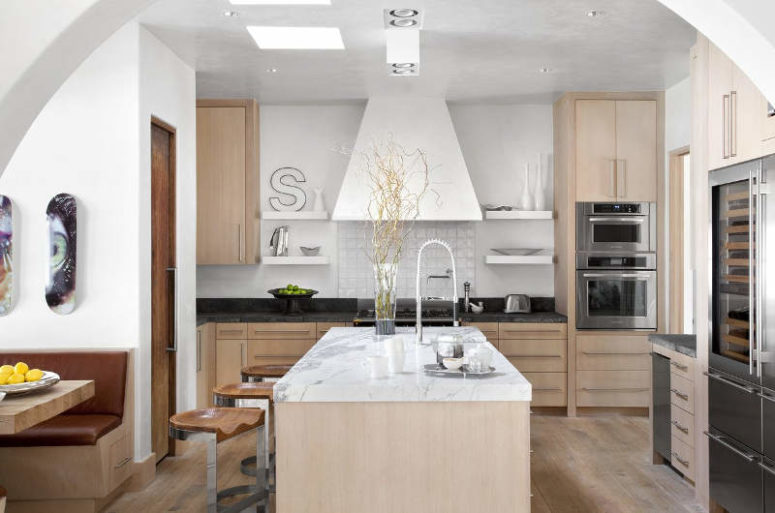 The kitchen is done in white and light-colored wood, I love the refined marble touches