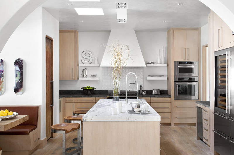 The kitchen is done in white and light colored wood, I love the refined marble touches
