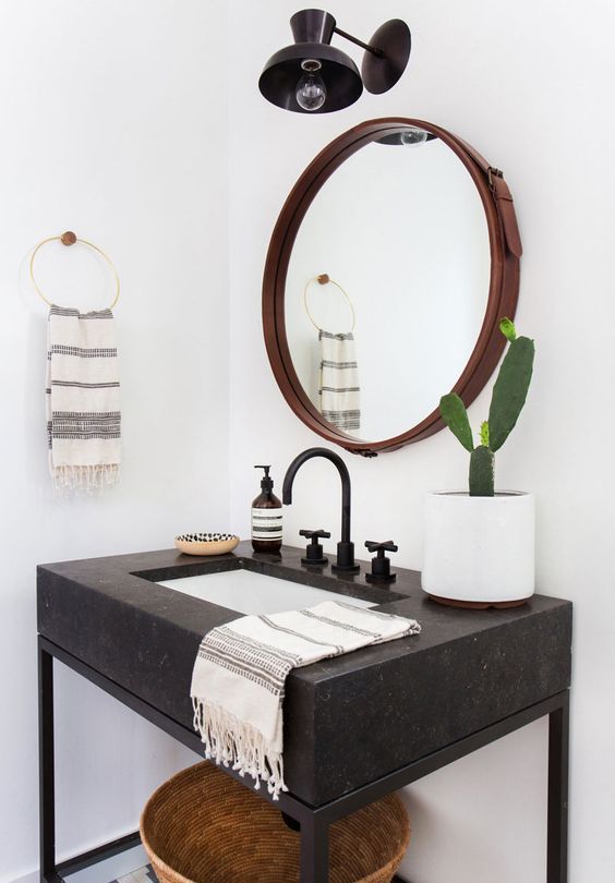 a black Corian and metal bathroom vanity with a shelf underneath
