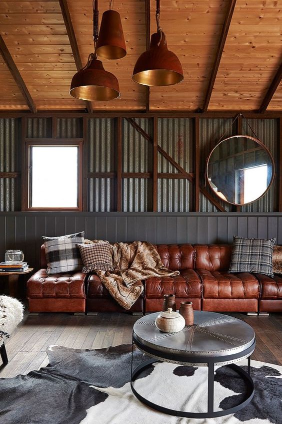 An industrial themed living room with a sofat brown leather sofa