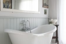 08 serene bathroom with a white bathtub on clawfoot legs and whitewashed wooden floors