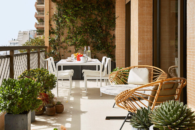 An outdoor dining zone is a dreamy one, and there are some wicker chairs to relax