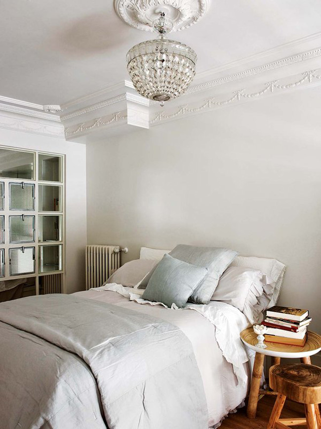 The bedroom is vintage, with molding, rustic stools and a glazed wall