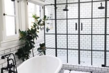 10 a freestanding tub is connected to the shower with a black faucet and a black glass pendant lamp over it
