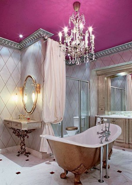 a vintage feminine bathroom with a pink ceiling and a lawfoot tub, a vintage crystal chandelier