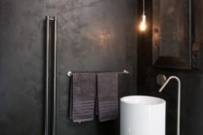 11 an industrial bathroom with a white free-standing sink that pops up