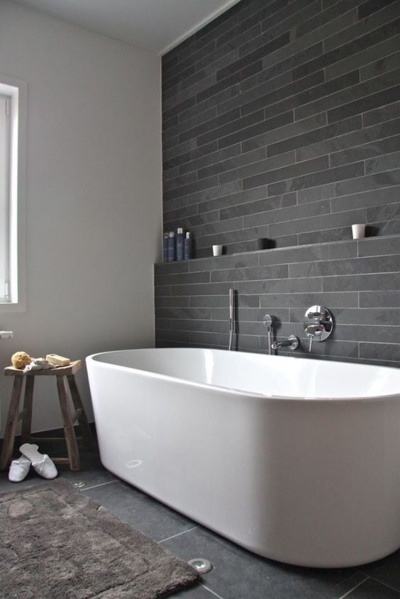 peaceful grey tile bathroom with a large freestanding bathtub