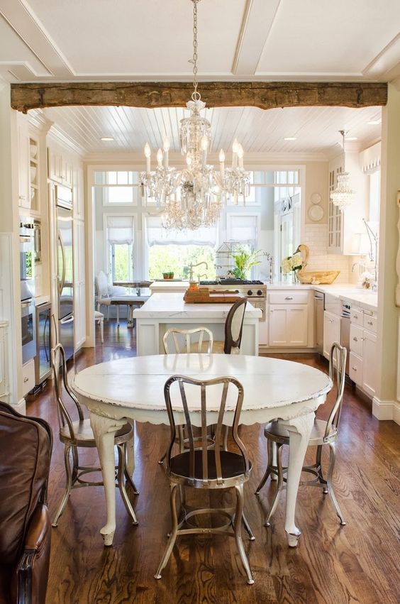 a rustic shabby chic kitchen with a sheer crystal chandelier on a white chain