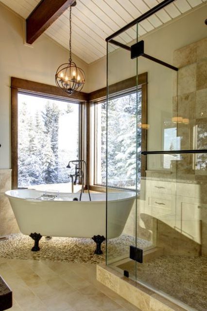 a white clawfoot bathtub with black legs next to the windows for a cool look