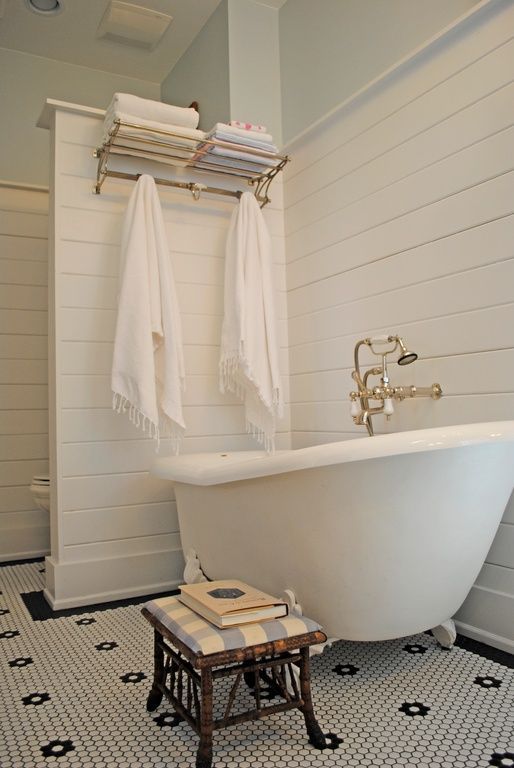 slipper clawfoot tub on white legs in a modern bathroom with vintage touches