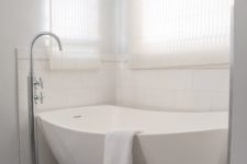 14 a neutral bathroom with a niche for a sculptural bathtub