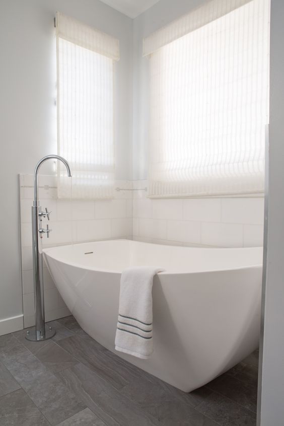 a neutral bathroom with a niche for a sculptural bathtub