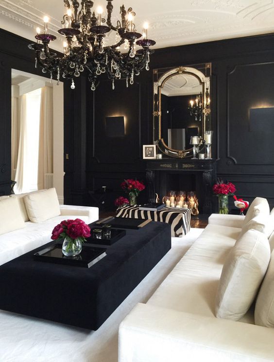 a black and white living room is given elegance and chic with a black chandelier and trasparent crystals