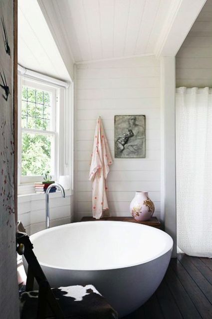 a large round bathtub next to the window for a view