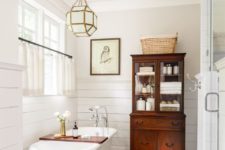 16 elegant vintage bathroom with a clawfoot tub, a wooden cabinet and a carpet