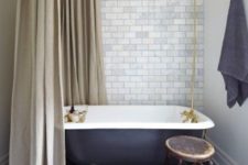 17 retro-inspired bathroom with a black clawfoot tub on metallic legs looks very elegant