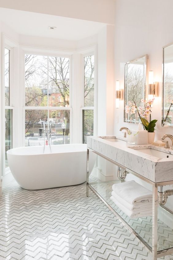 a comfy tub next to the window for a cool look, marble tiles