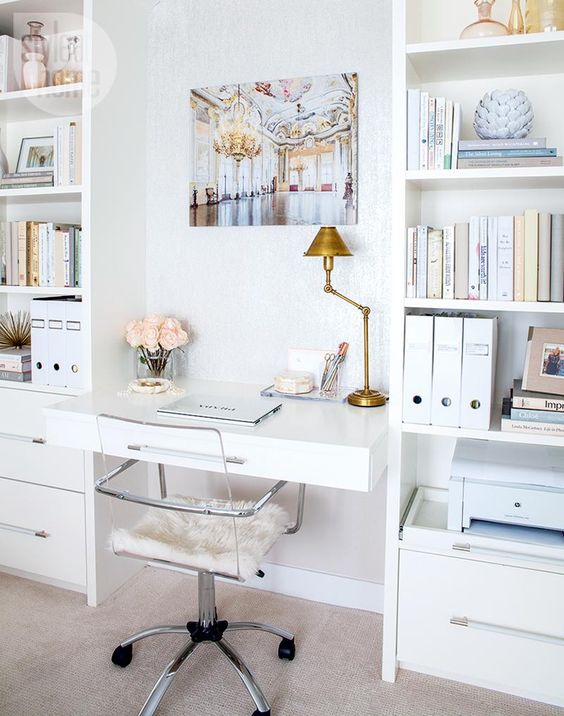 a small desk stuck between two bookcases with drawers