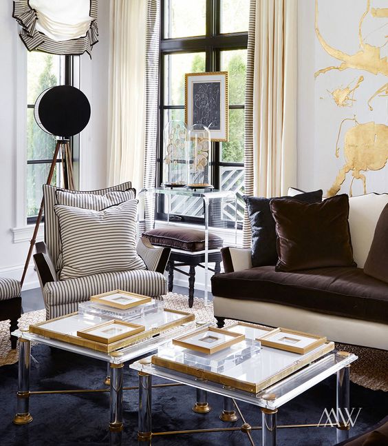 duo of lucite coffee tables with brass details make the living room exquisite