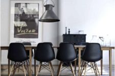 19 modern black chairs accentuate a light-colored wooden table