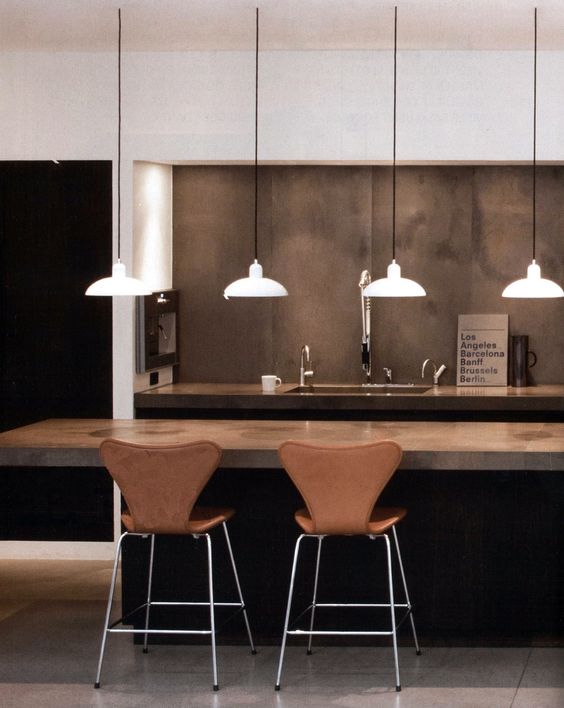 warm-colored concrete kitchen island and ocher leather chairs