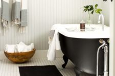 20 a black clawfoot bathtub with black legs makes this bathroom chic