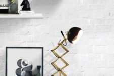 20 a retro lamp in brass and black with a rounded lampshade and a brass leg