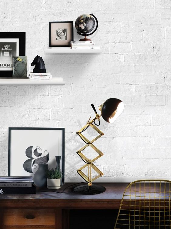 a retro lamp in brass and black with a rounded lampshade and a brass leg