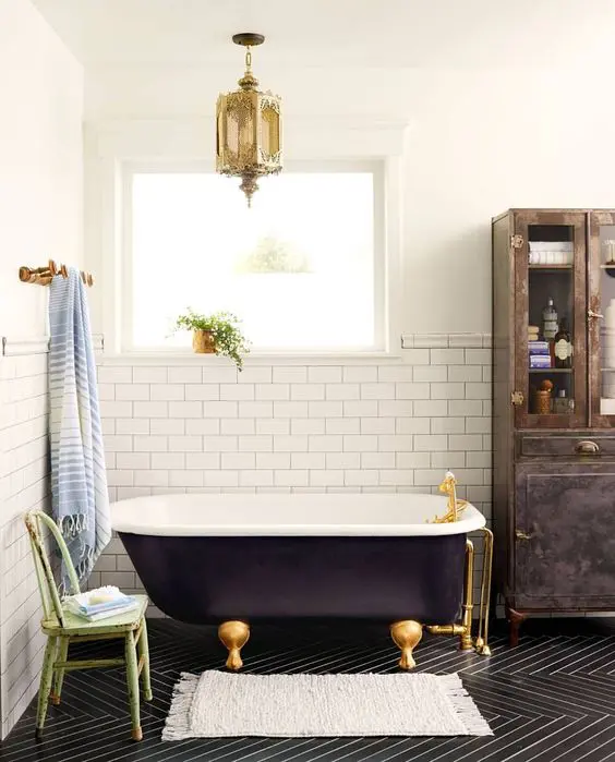 a black clawfoot tub and gold accents give the space an exquisite feel