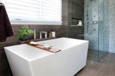 21 a home spa with a geometric bathtub next to the grey tile wall