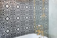 22 elegant retro bathroom with a black tub on black legs, brass details