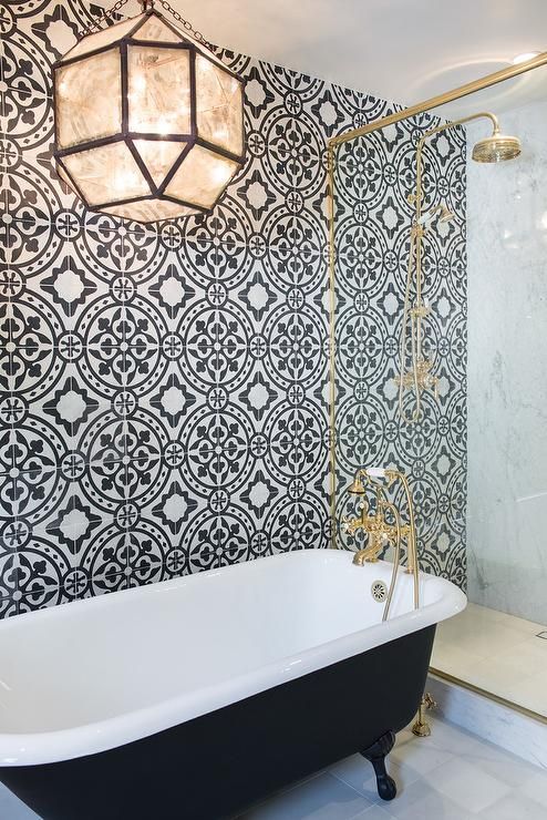 elegant retro bathroom with a black tub on black legs, brass details